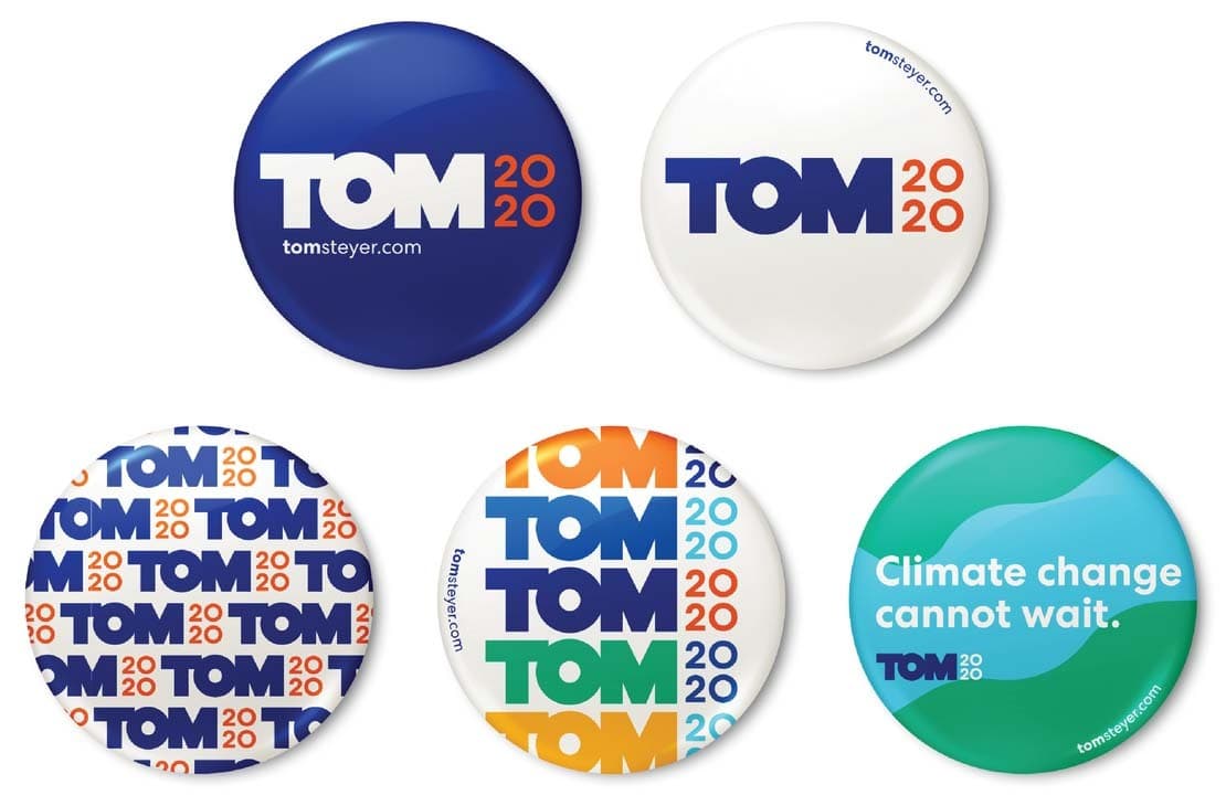 Five campaign buttons are shown. Two display “TOM 2020” in bold letters with different color schemes. One has a patterned design with “TOM” repeated. One features “TOM 2020” in various colors. The final button reads, “Climate change cannot wait.”.