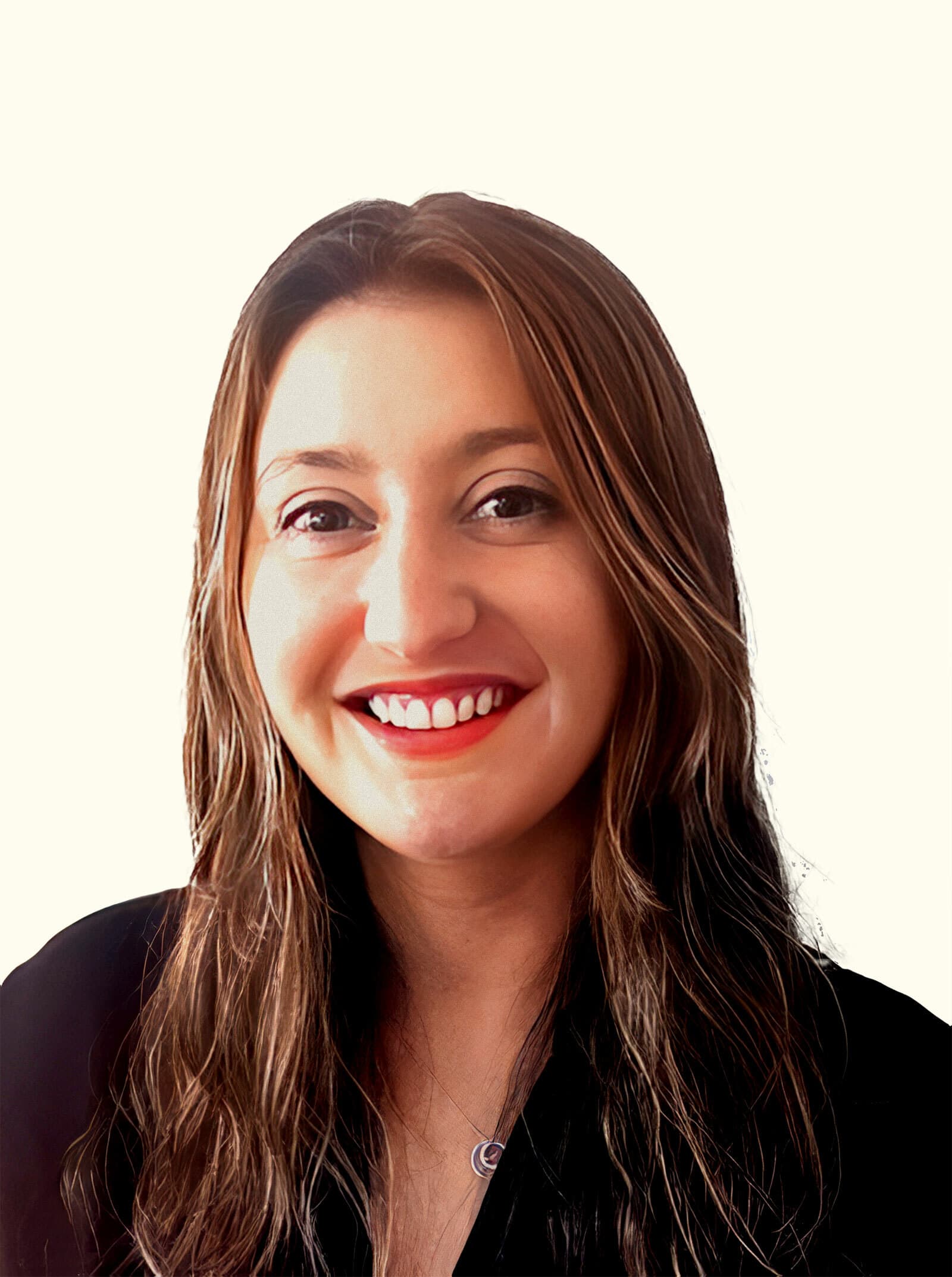 A person with long, brown hair is smiling against a plain, light-colored background. They are wearing a black top and a small necklace with a circular pendant.