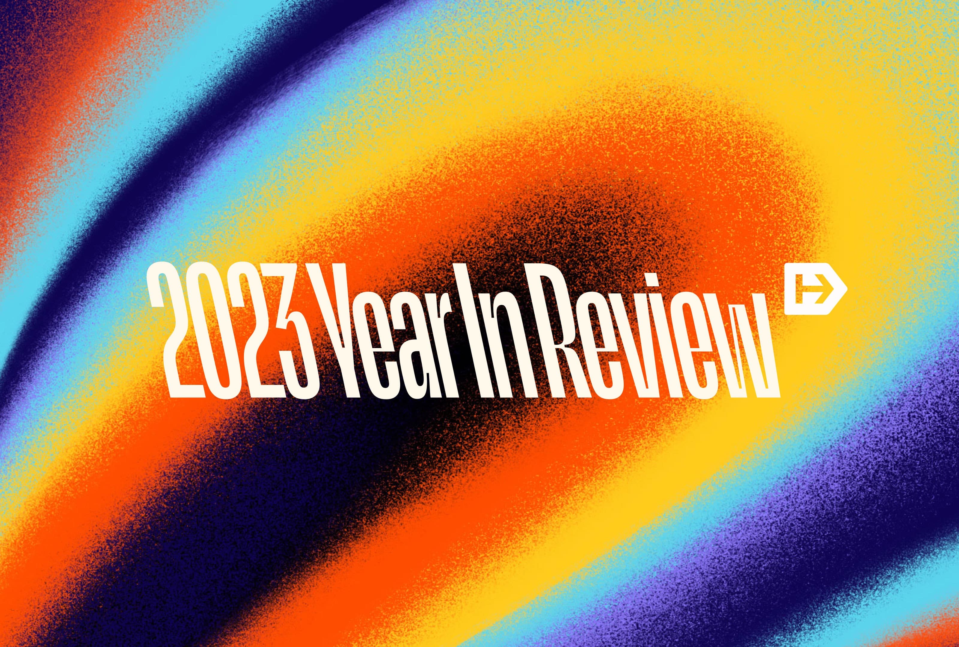 Bold text "2023 Year In Review" is centered on a colorful, swirling abstract background with orange, blue, purple, and yellow hues. A small arrow icon is placed to the right of the text.
