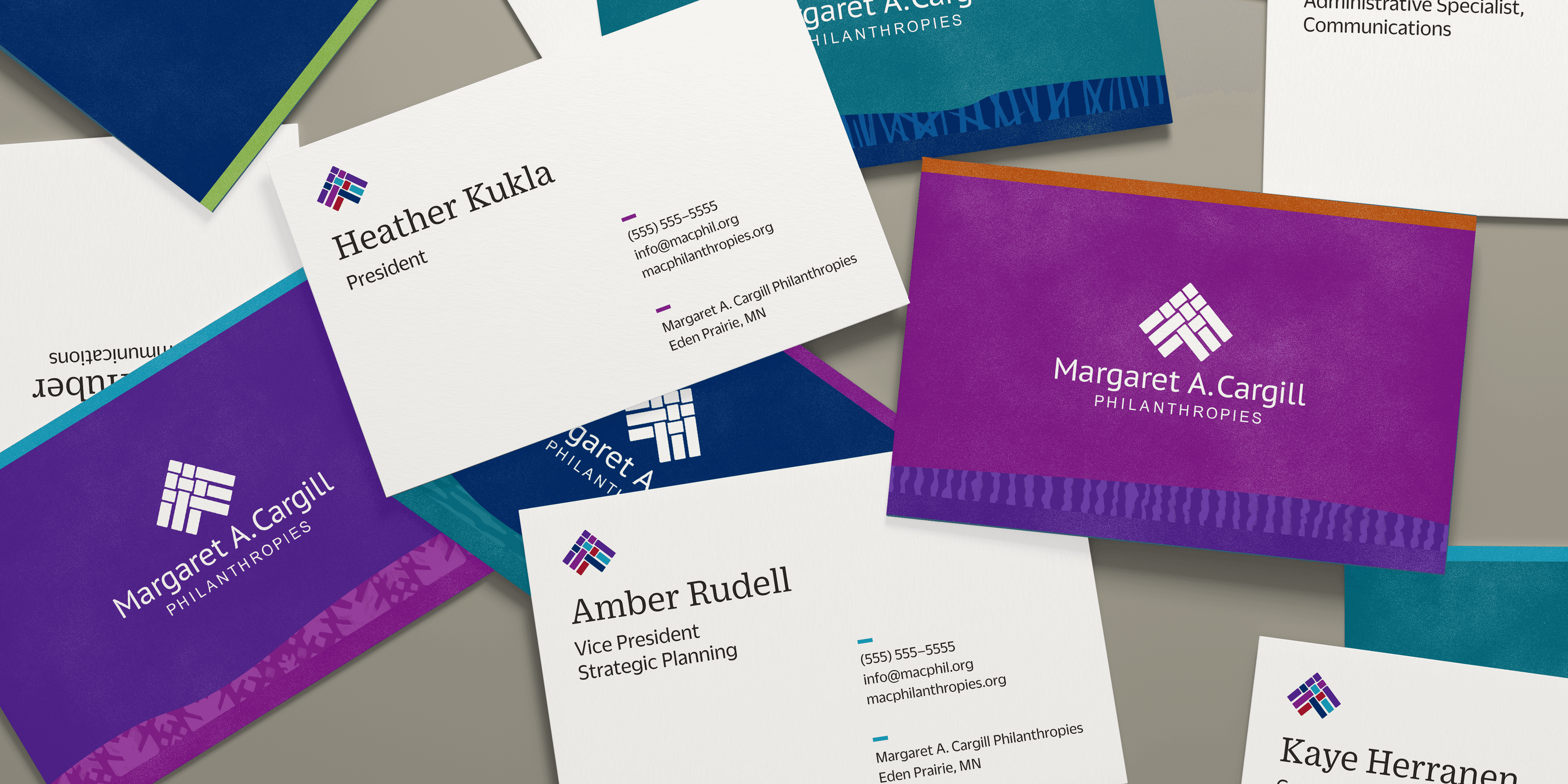 Various business cards are scattered, featuring different titles and names from Margaret A. Cargill Philanthropies. The design includes purple and teal colors with an interwoven square logo at the top left of each card.